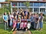Personen stehen gruppiert im Garten.