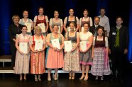 Personen stehen gruppiert auf einer Bühne