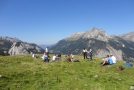 Personen auf Alm, im Hintergrund Berge