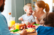 Familie sitzt am Esstisch.