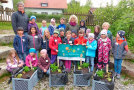 Gruppenbild der Schulklasse hinter Pflanzkisten