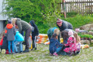 Mehrere Kinder mit über zwei Pflanzkisten gebeugt