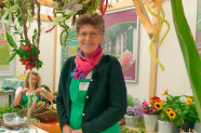 Frau an einem Stand mit gebunden Kränzen.