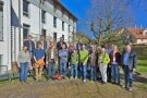 Personen stehen gruppiert im Garten.