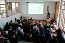 Teilnehmer sitzen im Foyer auf Stühlen während eines Vortrags