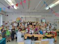 Schulkinder stehen im Klassenzimmer und halten Urkunden nach oben.