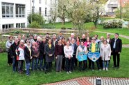 Personengruppe steht auf einer Wiese