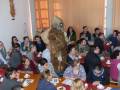 Krampus geht zwischen Studierenden durch Saal